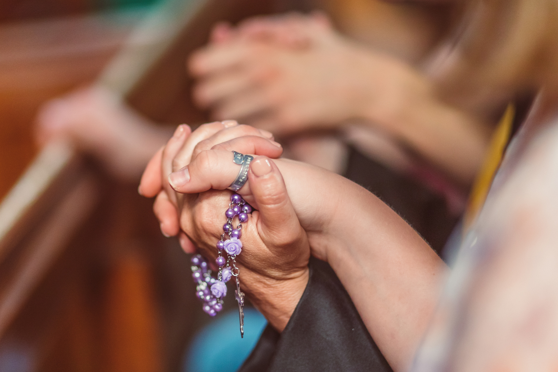 Selective Focus Photo of People holding each other's Hands while Praying 